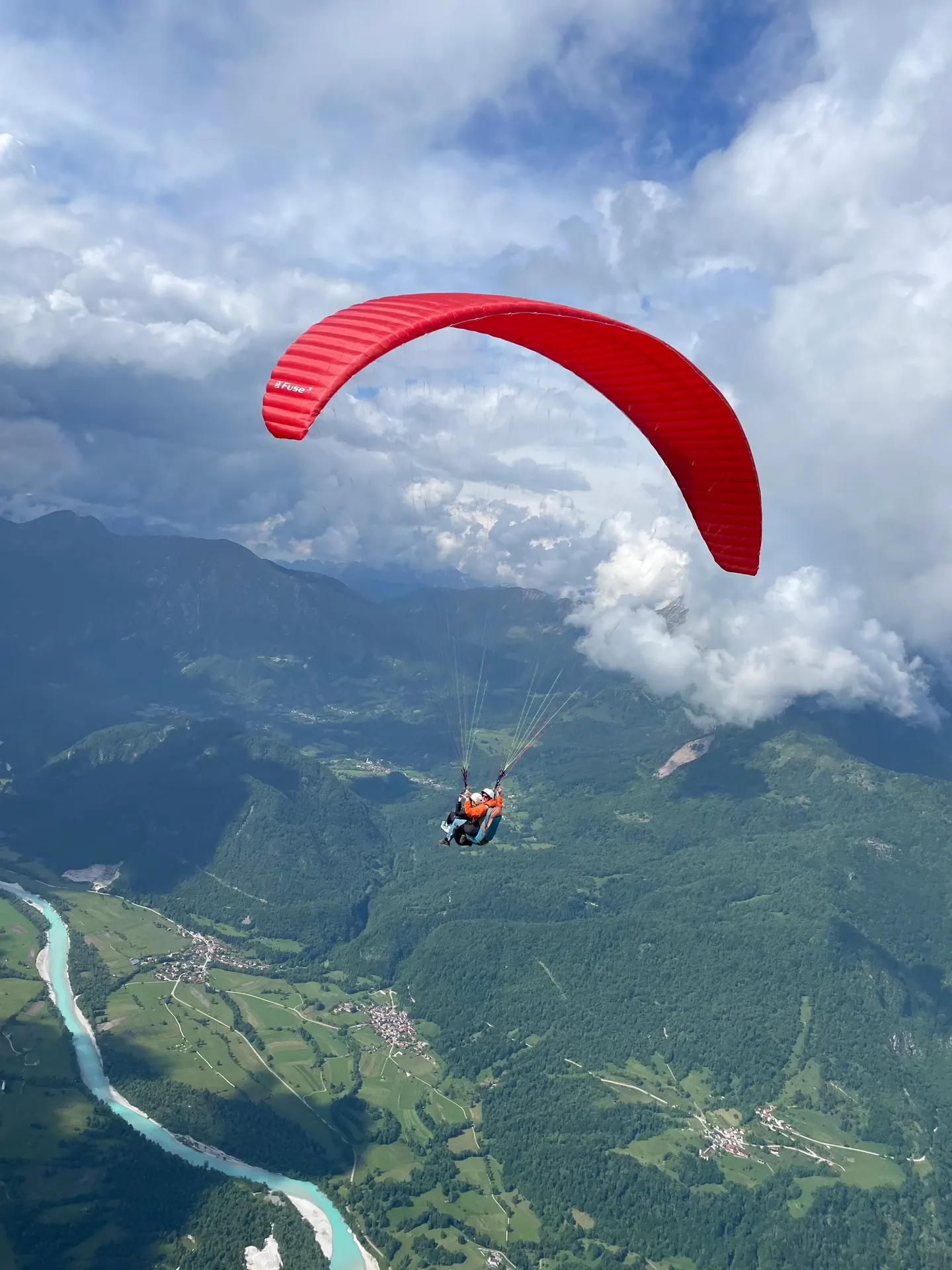 Tandem paraglider over the Soča Valley near Kobarid